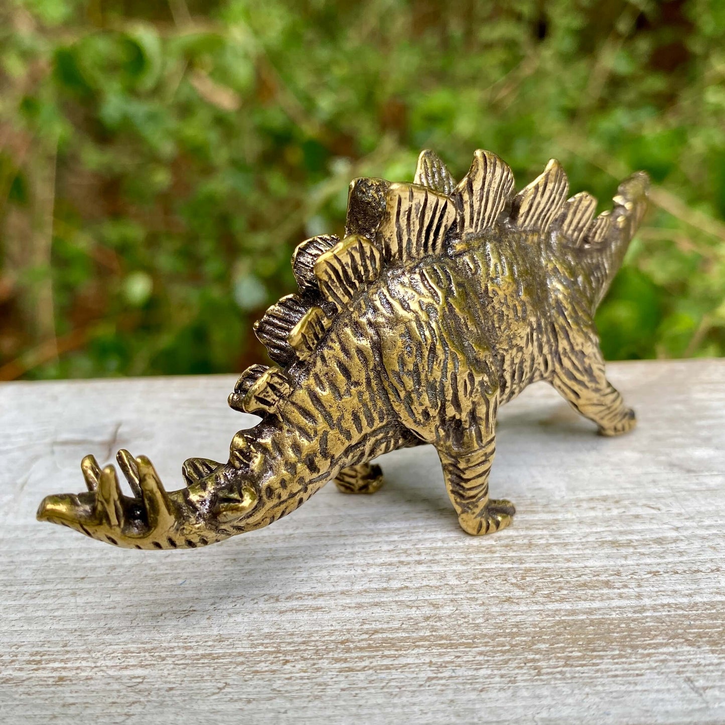 Solid brass Stegosaurus dinosaur figurine by Wild Brass, symbol of protection, strength, and resilience with detailed dinosaur scales.