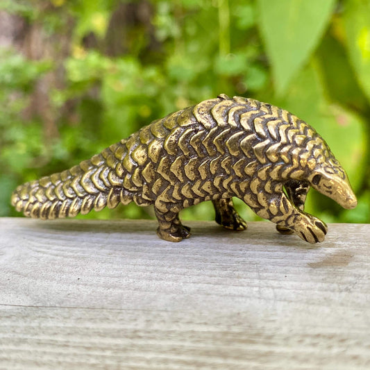 Solid brass pangolin sculpture by Wild Brass, detailed figure symbolizing protection, patience, and transformation.