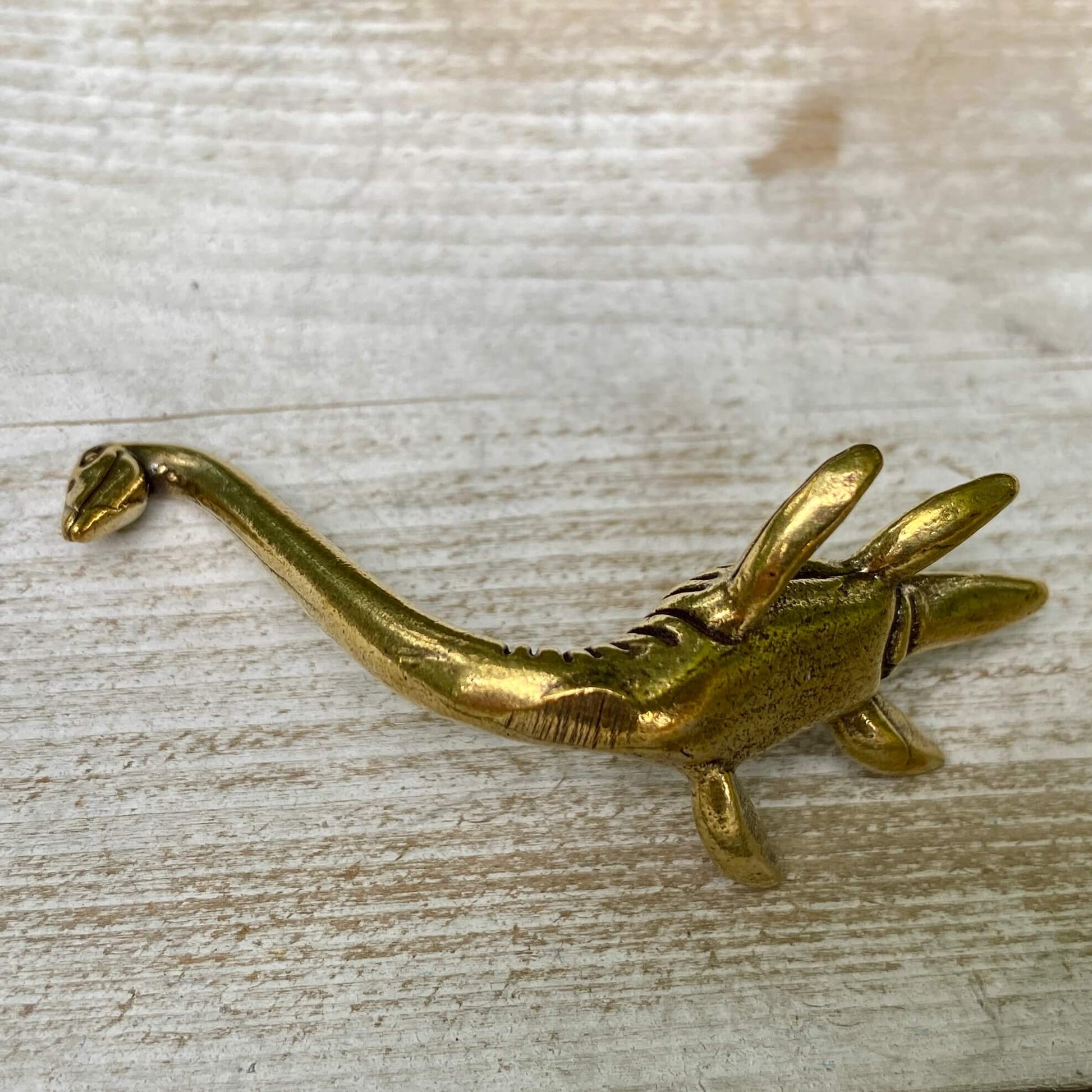 Solid brass Loch Ness Monster figurine by Wild Brass, symbol of mystery and magic, detailed underwater creature sculpture.