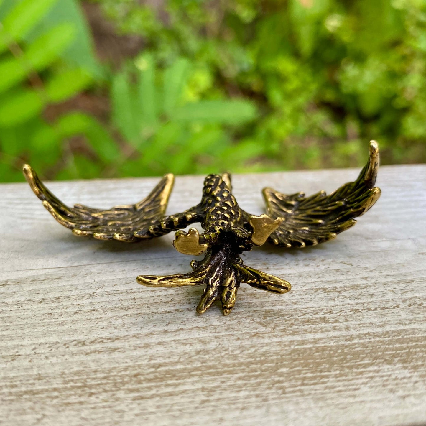Solid brass phoenix sculpture by Wild Brass symbolizing rebirth and strength, detailed bird with outstretched wings.