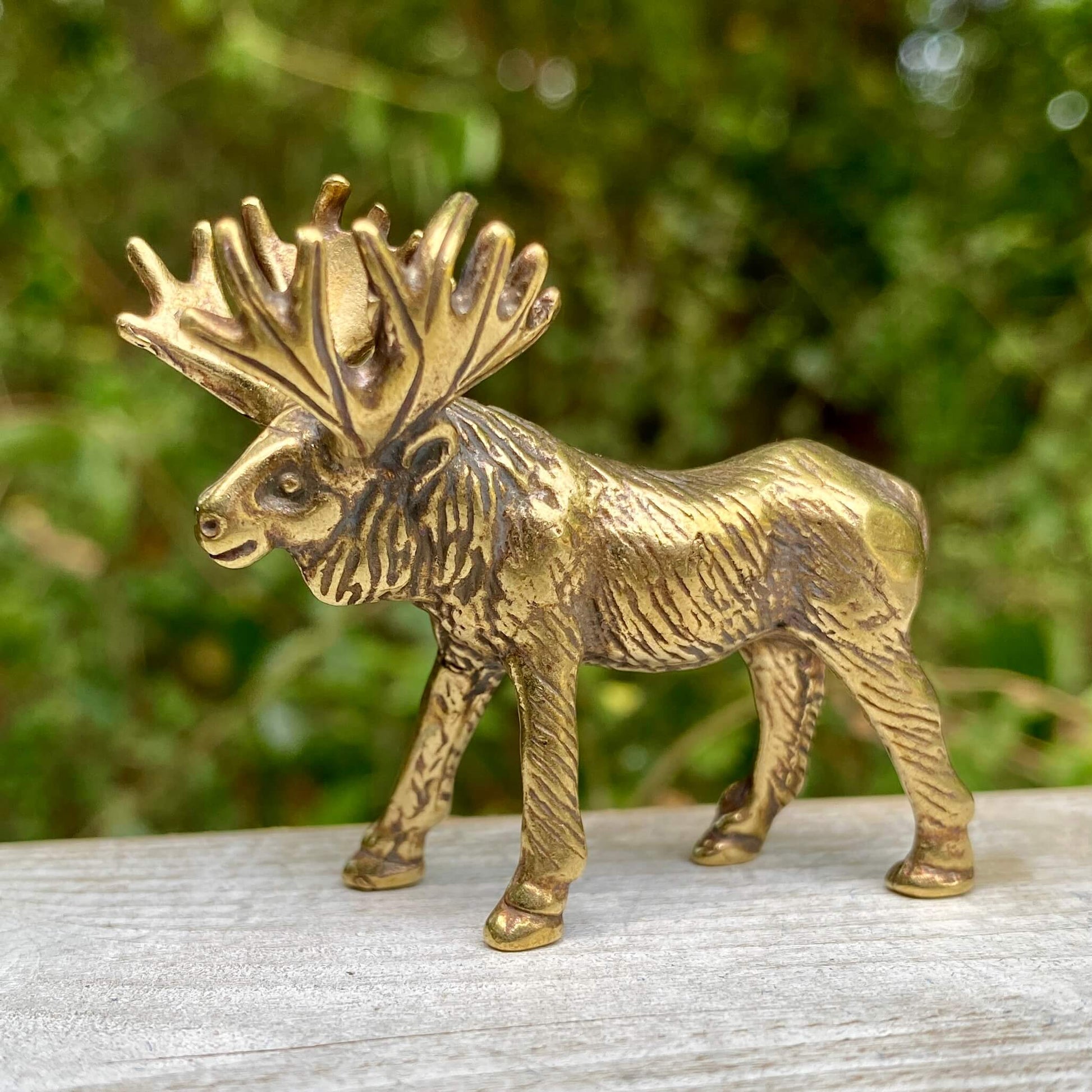 Solid brass moose figurine by Wild Brass, showcasing detailed craftsmanship and a majestic stance symbolizing strength and wisdom.
