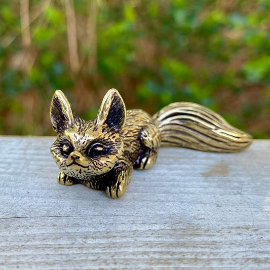 Solid brass fox sculpture in crouching pose by Wild Brass, symbolizing cleverness, adaptability, and trickery.