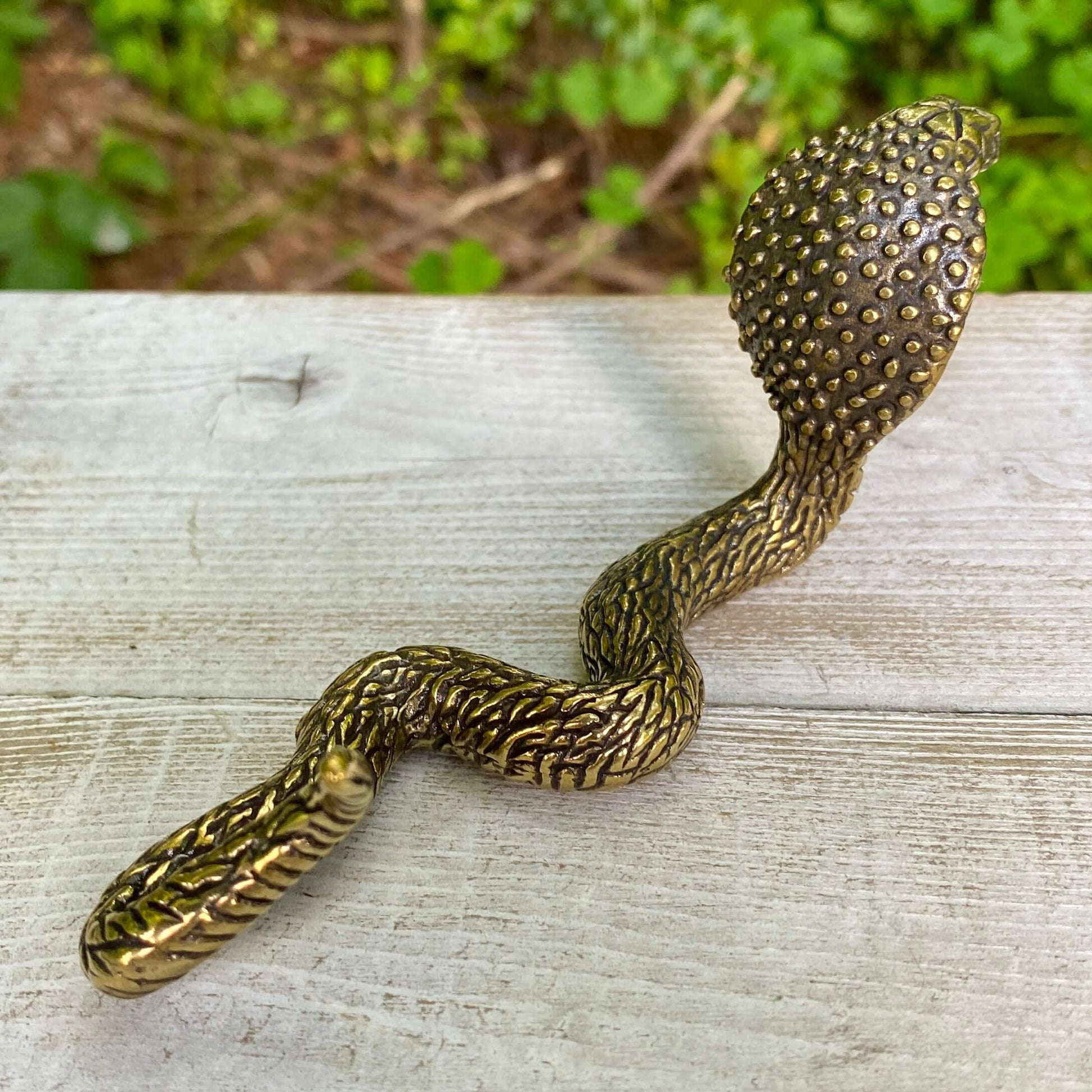 Solid brass cobra snake figurine by Wild Brass, symbol of transformation, power, and protection, showcasing detailed craftsmanship.