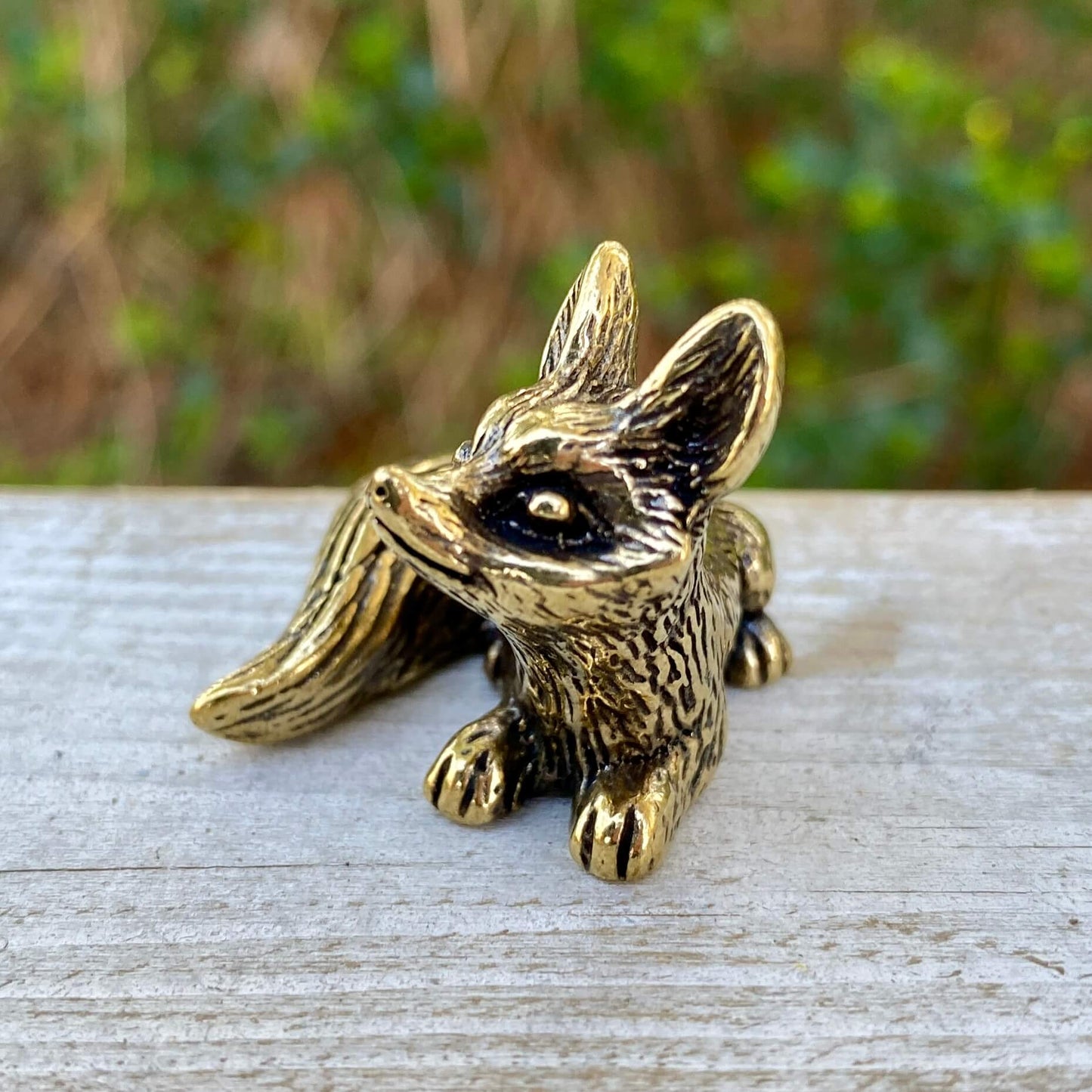 Solid brass fox sculpture from Wild Brass, depicting a sitting fox symbolizing cleverness and adaptability.