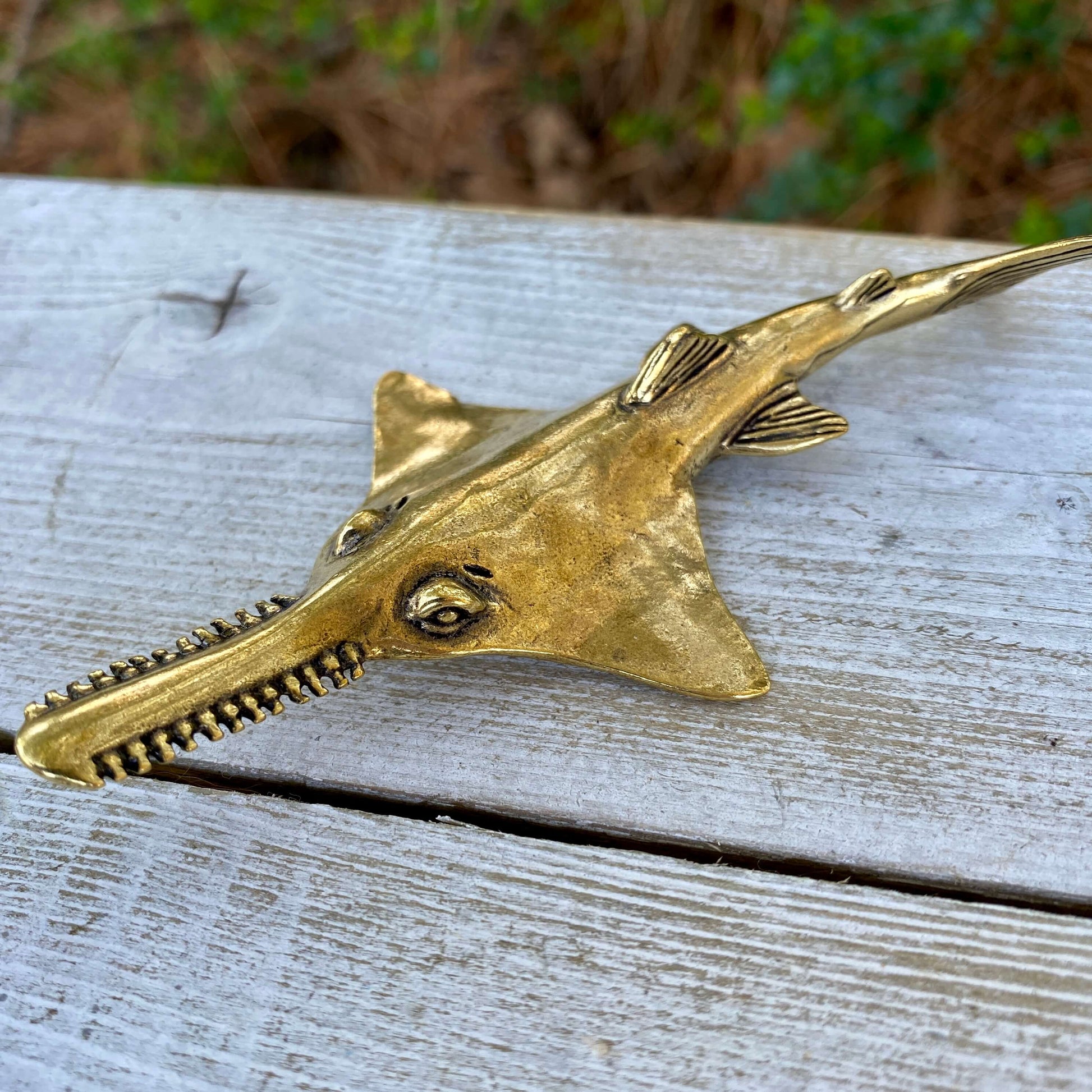 Solid brass sawfish sculpture by Wild Brass, showcasing detailed fins and fierce expression symbolizing focus and power.