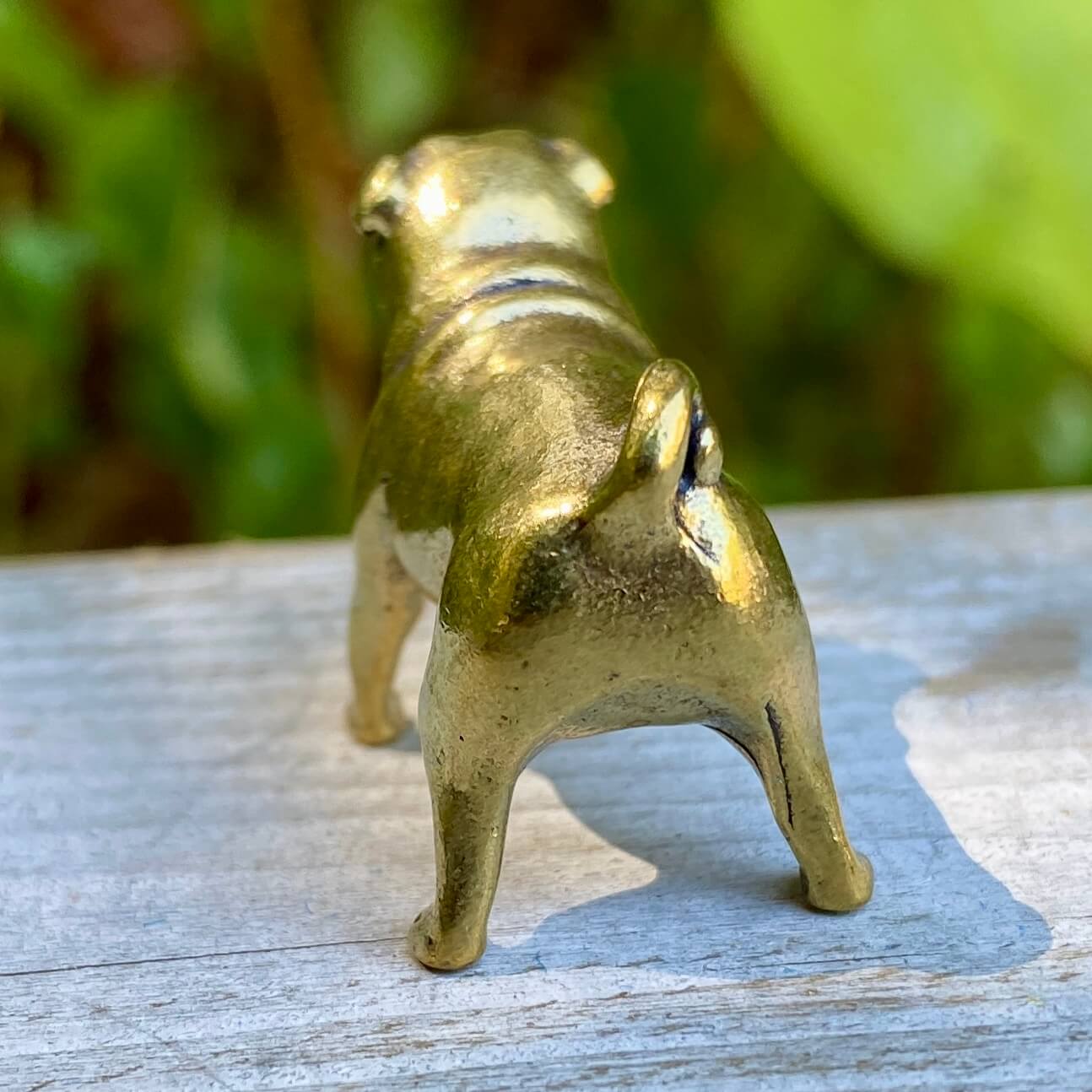 Solid brass pug figurine by Wild Brass, symbol of devotion, charm, and good fortune, shown sitting with detailed features.