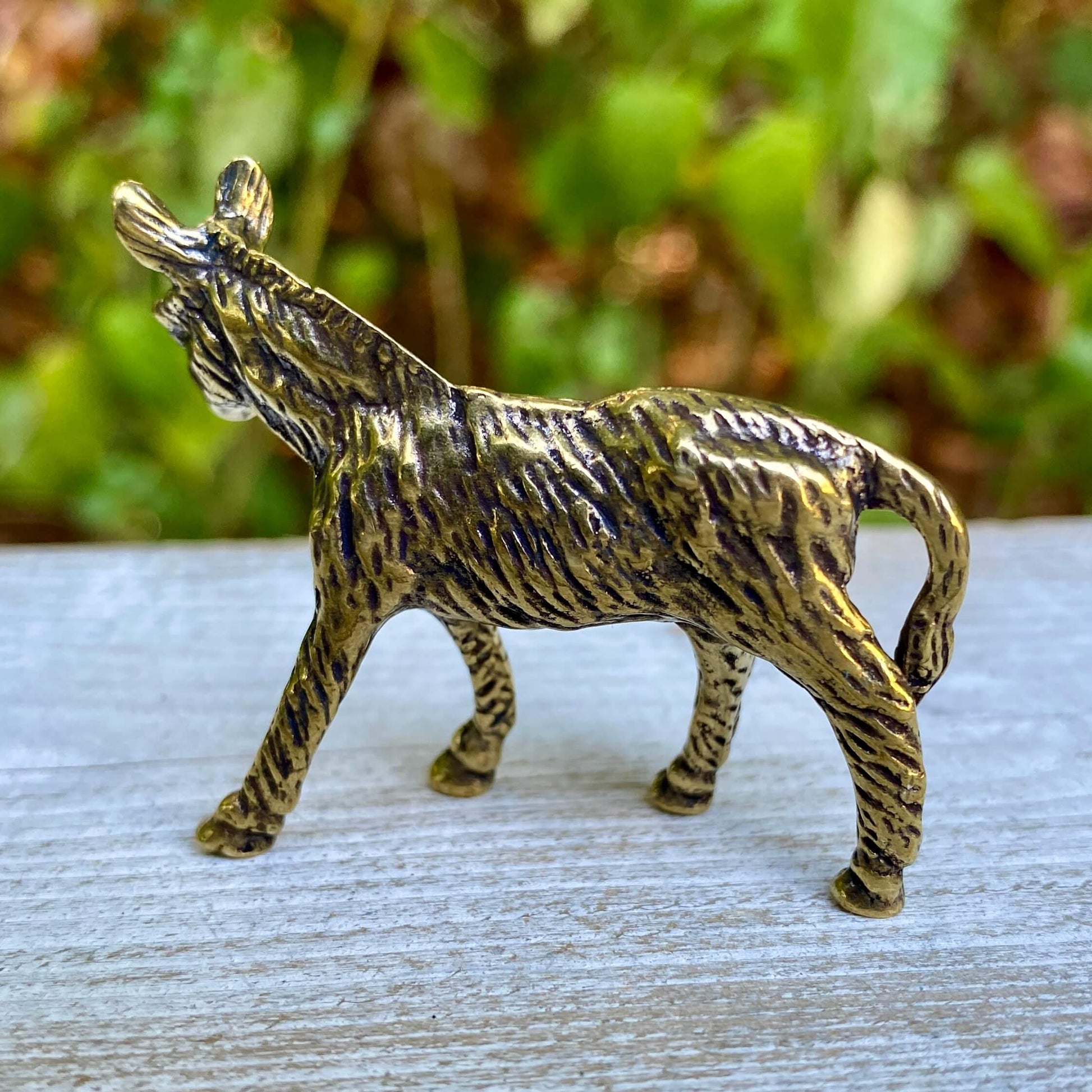 Solid brass donkey sculpture by Wild Brass, symbol of perseverance and humility, detailed metallic figurine on a neutral background.