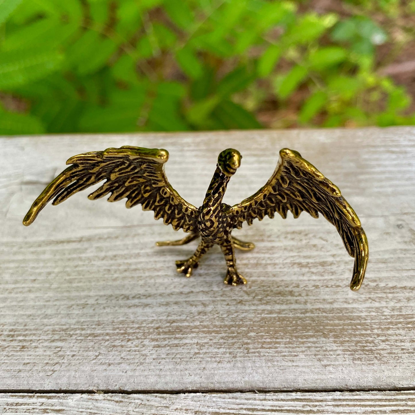 Solid brass phoenix sculpture by Wild Brass, symbol of rebirth and strength, featuring detailed sculpted bird with outstretched wings.