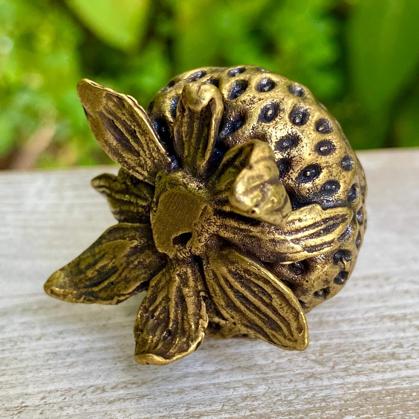 Solid brass strawberry sculpture by Wild Brass, symbol of love and abundance, detailed close-up of the handmade fruit ornament.