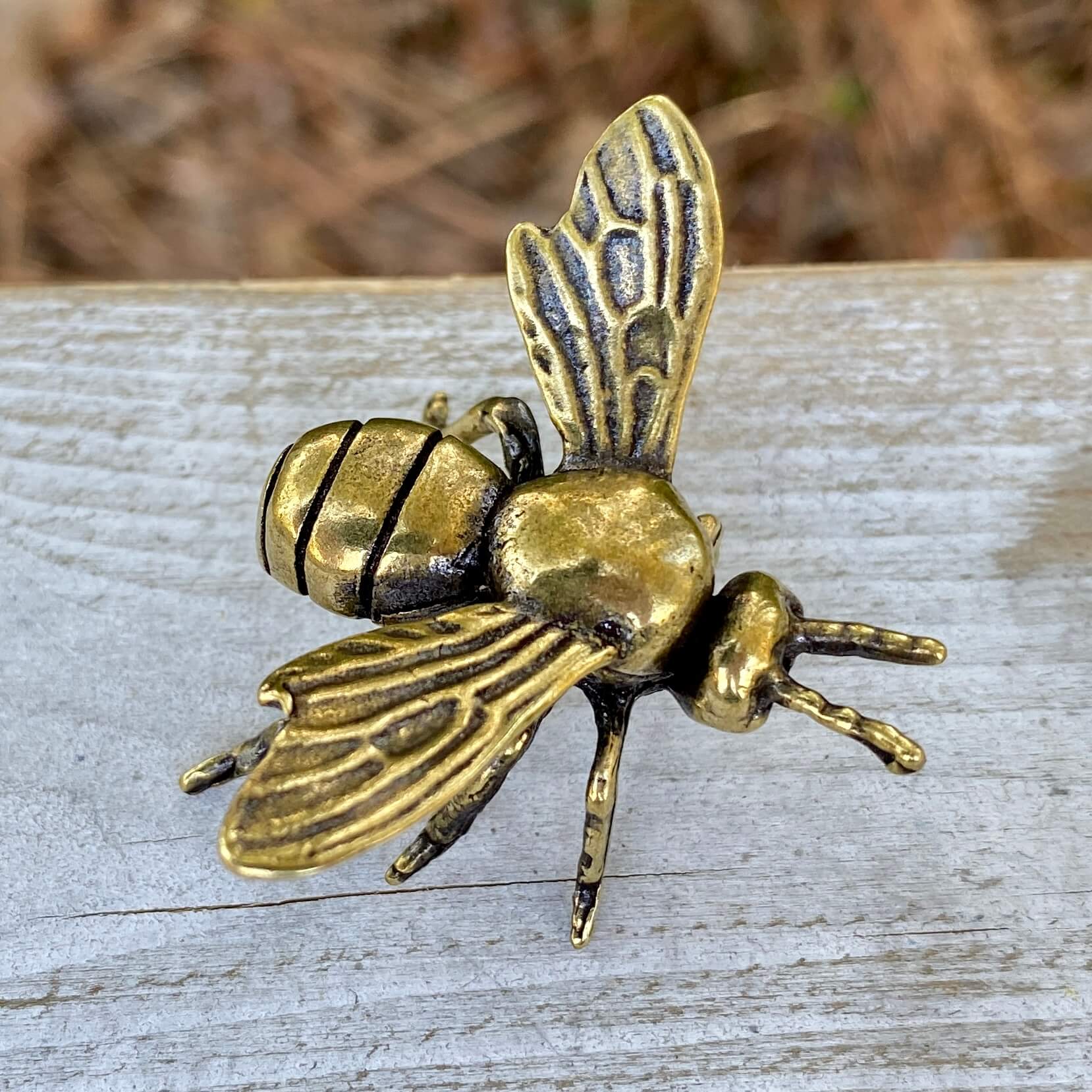 Solid brass bee sculpture by Wild Brass, symbol of harmony and beauty, featuring detailed bee design on a natural background.