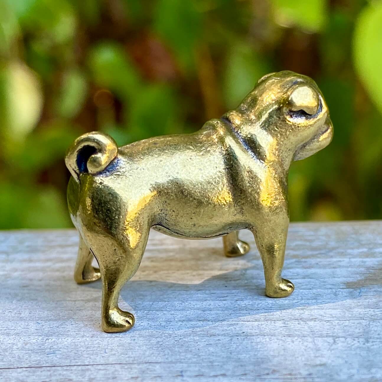 Solid brass pug figurine by Wild Brass, detailed dog sculpture symbolizing devotion, charm, and good fortune.