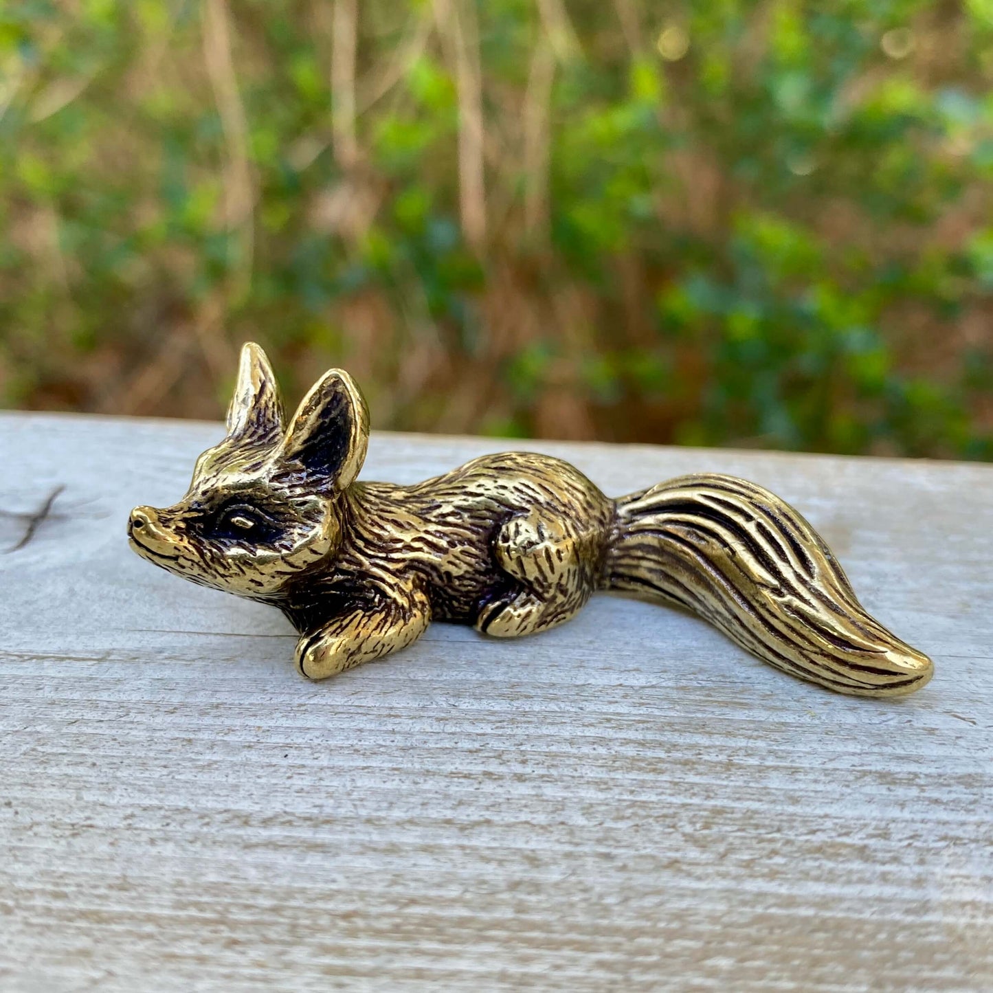 Solid brass fox sculpture in a crouching pose, symbolizing cleverness and adaptability, designed by Wild Brass.