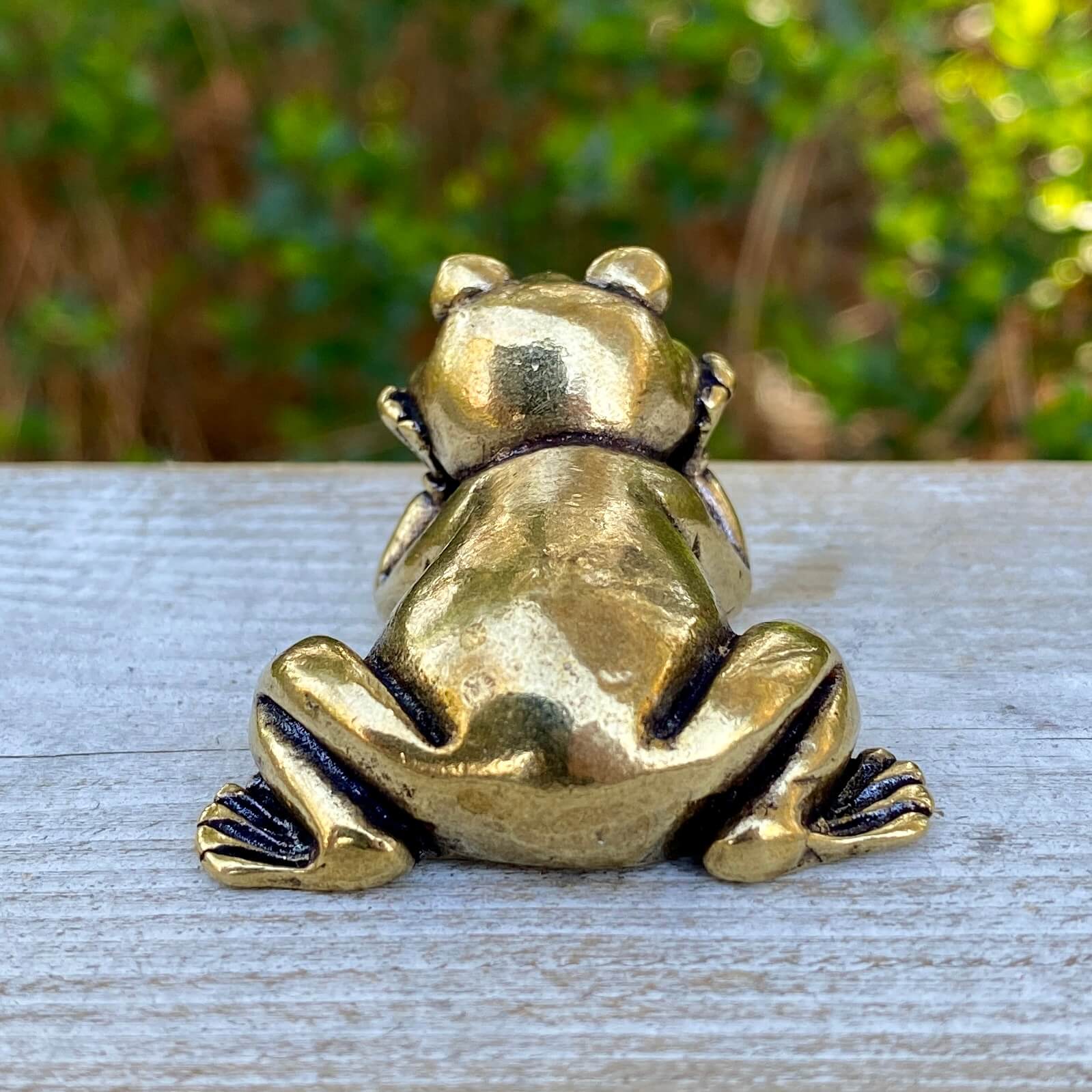 Solid brass frog laying figurine by Wild Brass, symbol of transformation, renewal, and luck, with detailed craftsmanship.