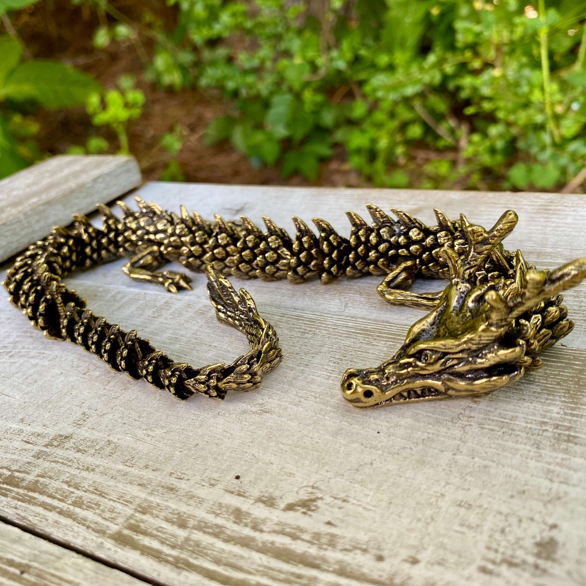 Solid brass large bendable dragon figurine by Wild Brass, featuring detailed scales and a dynamic pose symbolizing power and wisdom.
