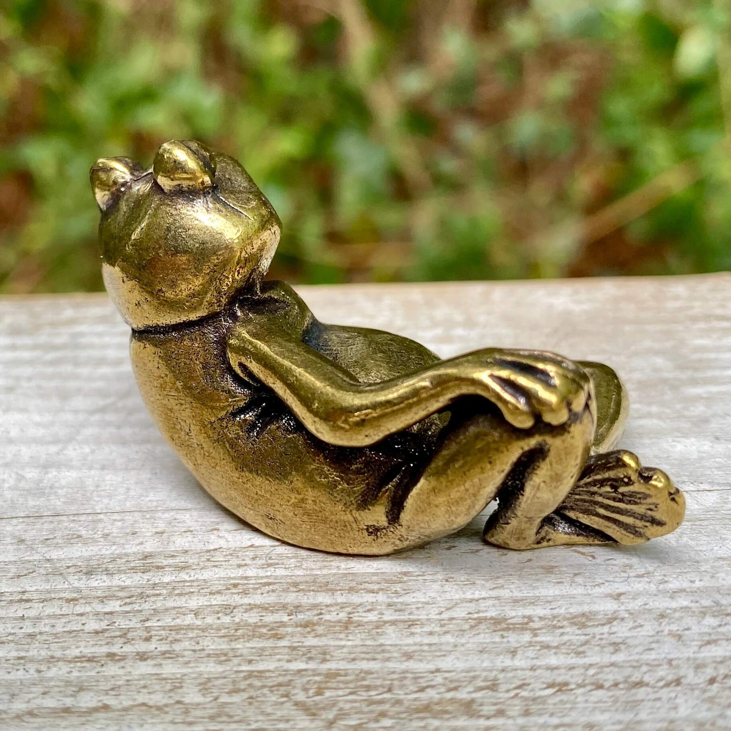 Solid brass frog figurine from Wild Brass, showcasing a lounging frog symbolizing transformation, renewal, and luck.