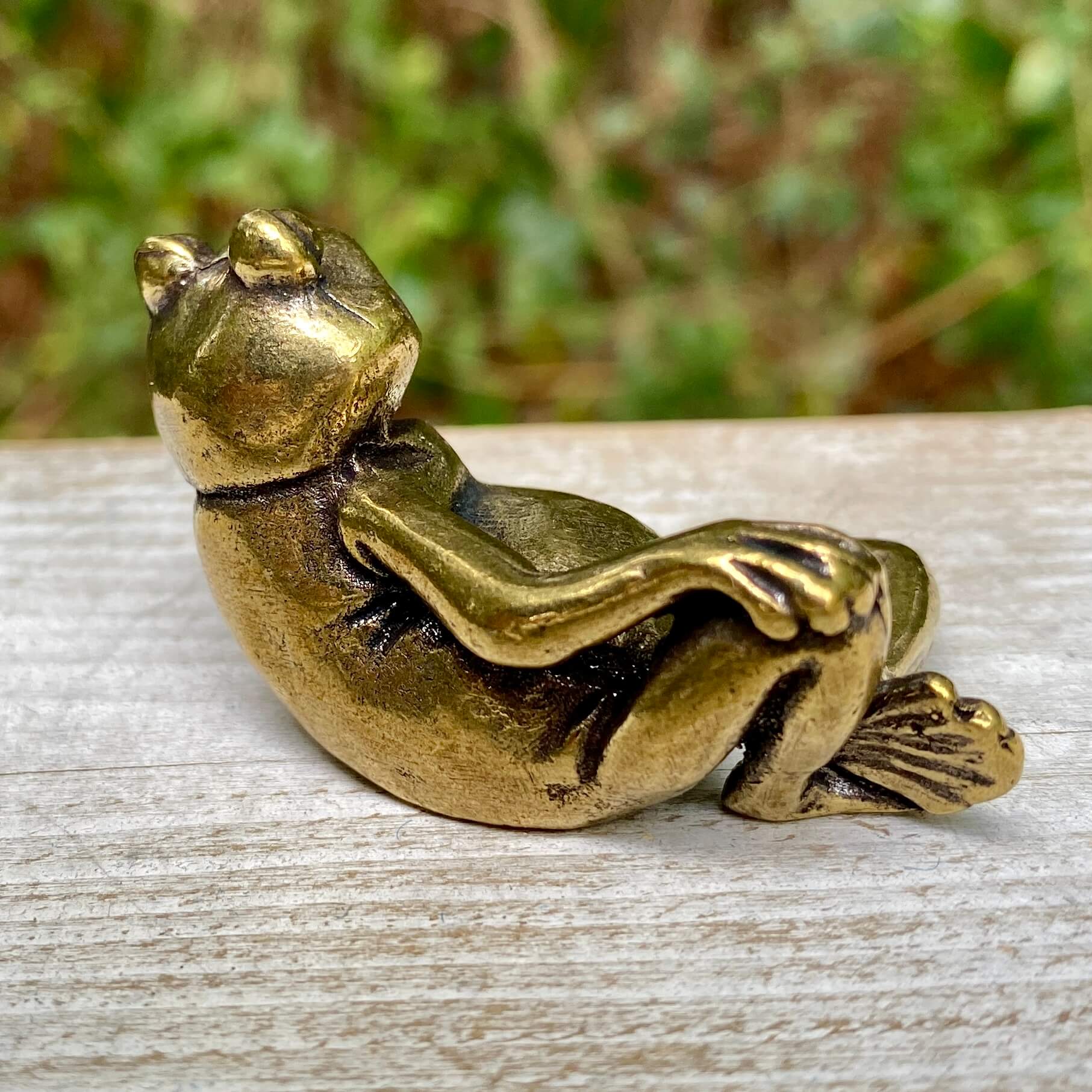 Solid brass frog figurine from Wild Brass, showcasing a lounging frog symbolizing transformation, renewal, and luck.