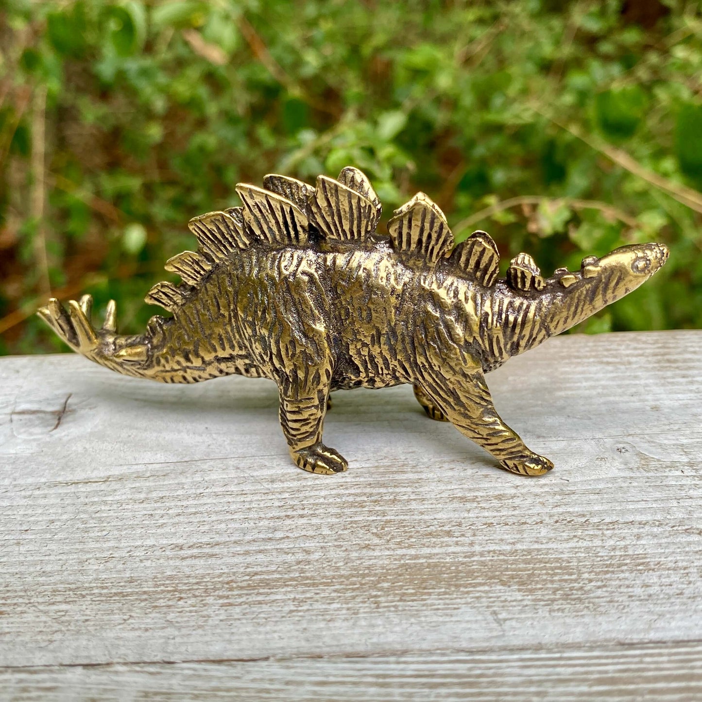 Solid brass Stegosaurus dinosaur sculpture by Wild Brass, symbol of protection, strength, and resilience, with detailed textured body.