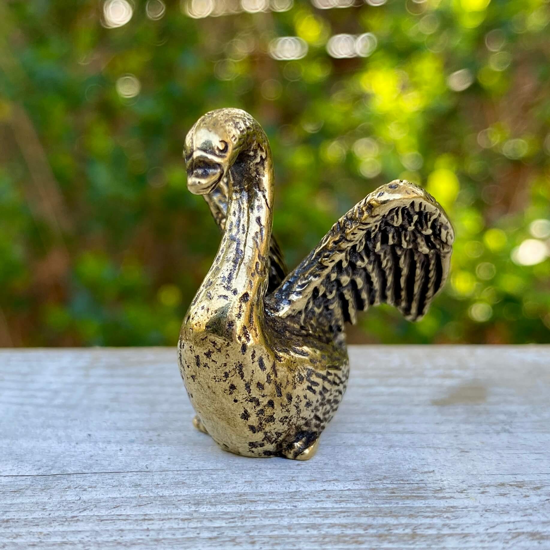 Solid brass swan figurine by Wild Brass, symbol of beauty, grace, and elegance, with detailed curved neck and smooth finish.