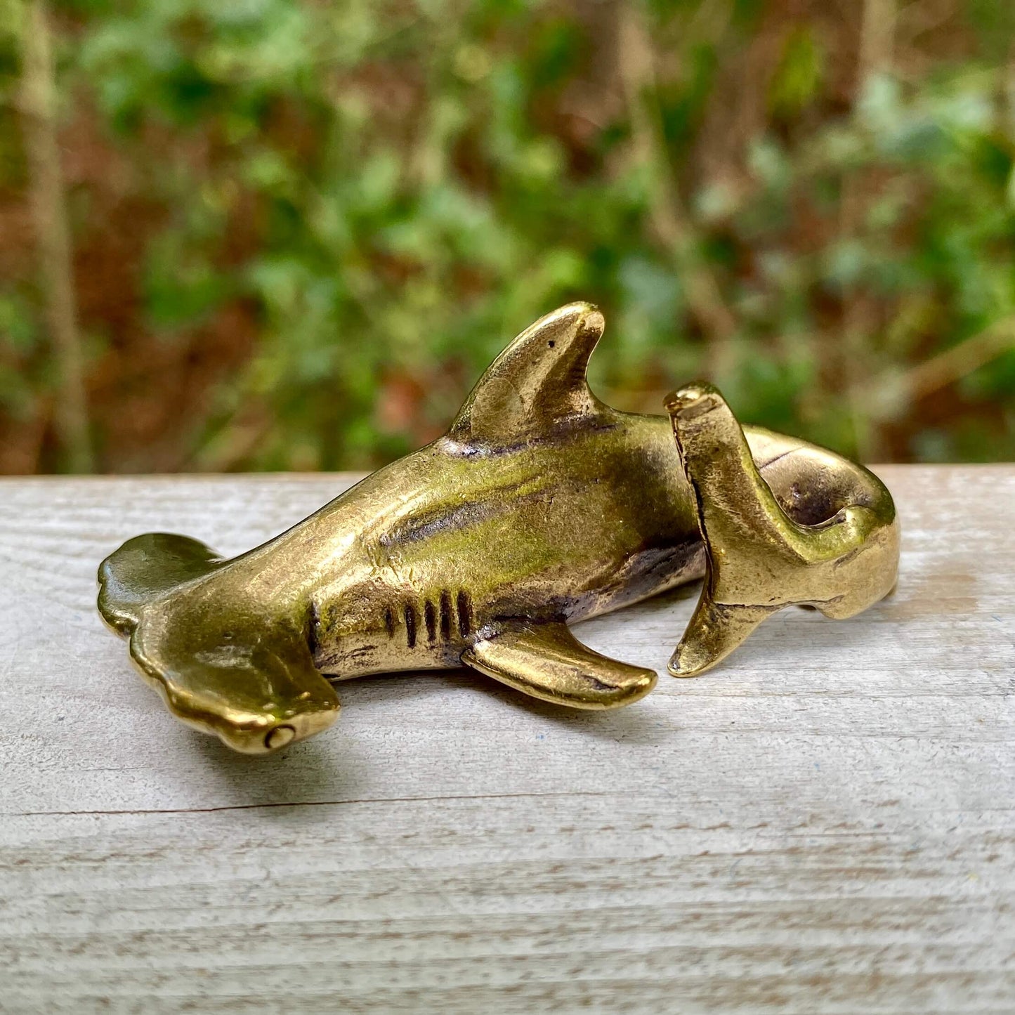 Solid brass hammerhead shark sculpture by Wild Brass, symbolizing perception, adaptability, and strength, detailed in the image.