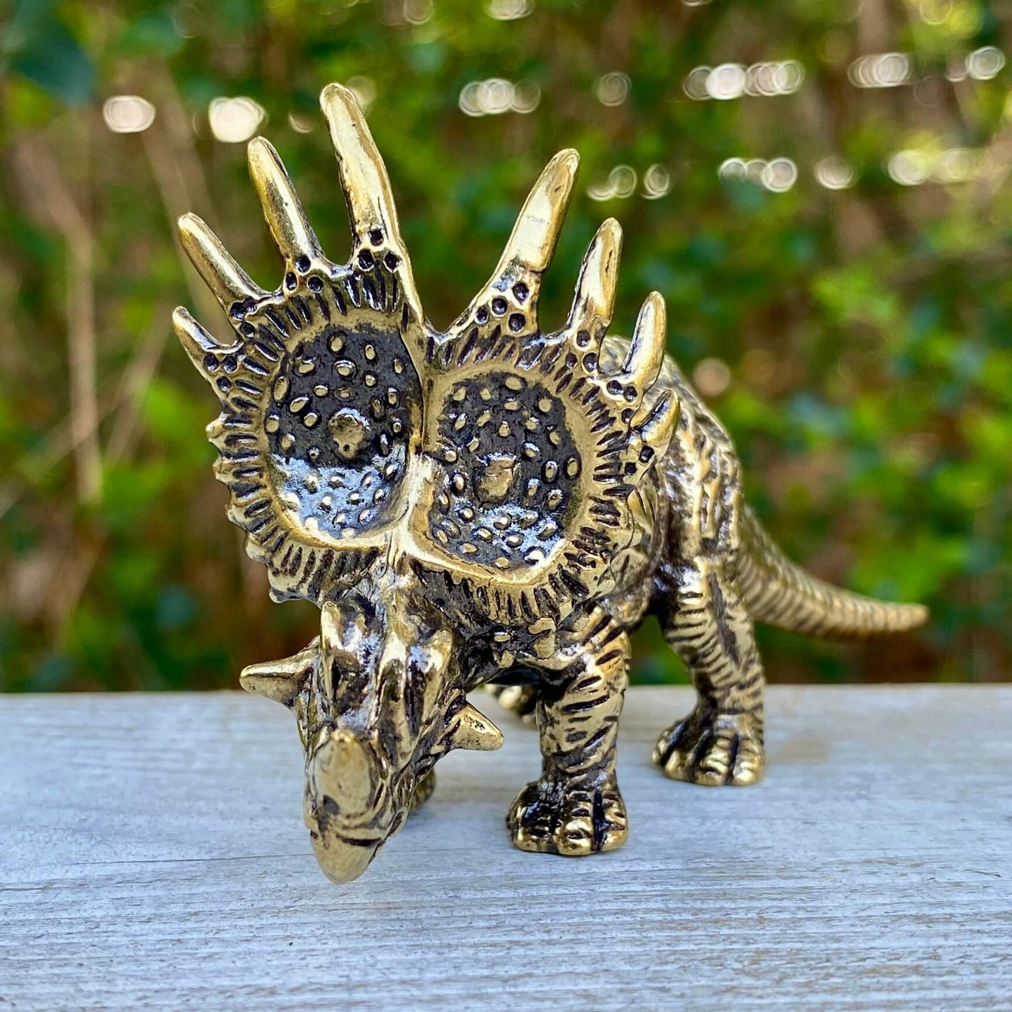 Solid brass Triceratops dinosaur sculpture by Wild Brass, symbolizing protection, strength, and courage, detailed and polished.