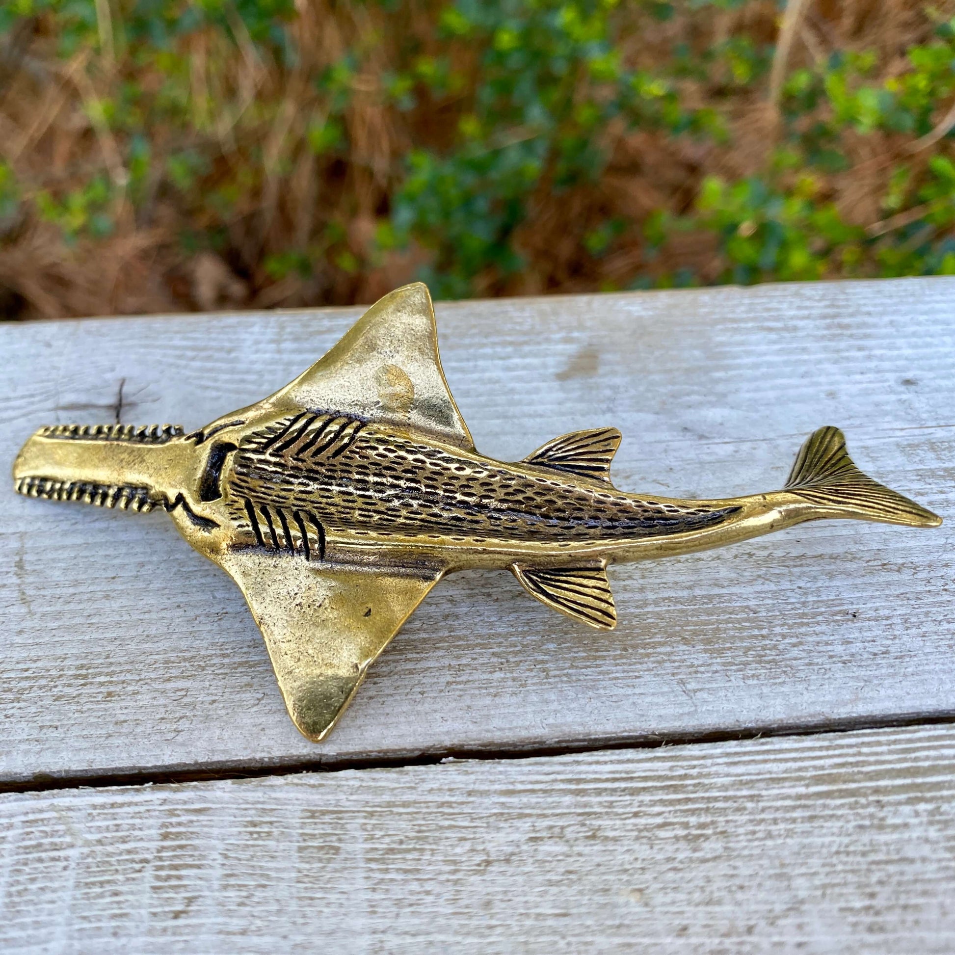 Solid brass sawfish sculpture by Wild Brass, symbolizing focus, power, and mystery, with detailed craftsmanship and polished finish.