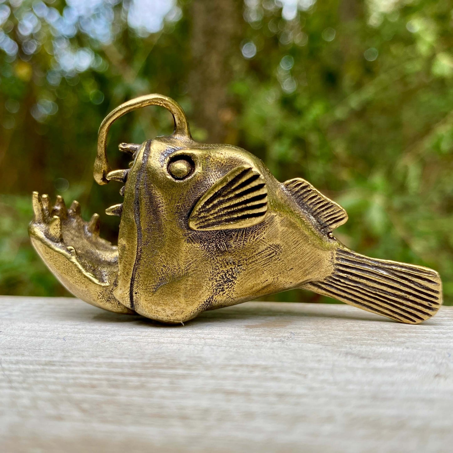 Solid brass angler deep sea fish symbol by Wild Brass, showcasing intricate details and a mysterious, adaptable sea creature design.