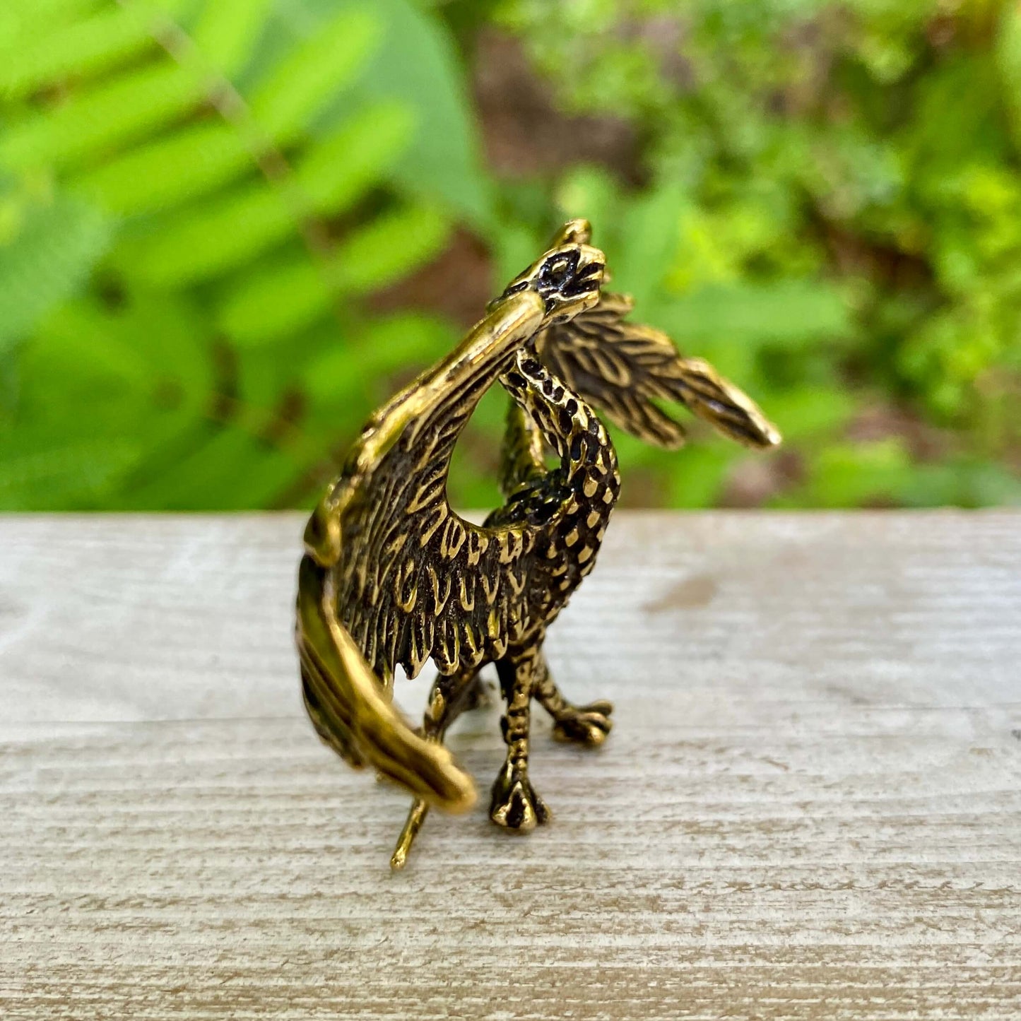 Solid brass phoenix sculpture by Wild Brass, symbol of rebirth and strength, featuring detailed craftsmanship and a majestic design.