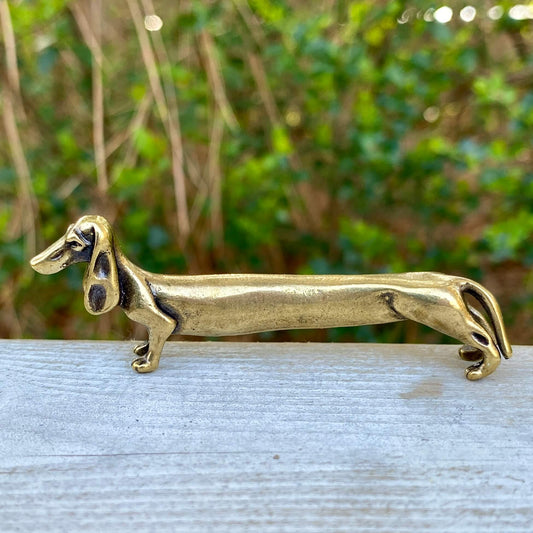 Solid brass Dachshund dog sculpture by Wild Brass, symbolizing courage, loyalty, and tenacity, shown in a detailed close-up image.