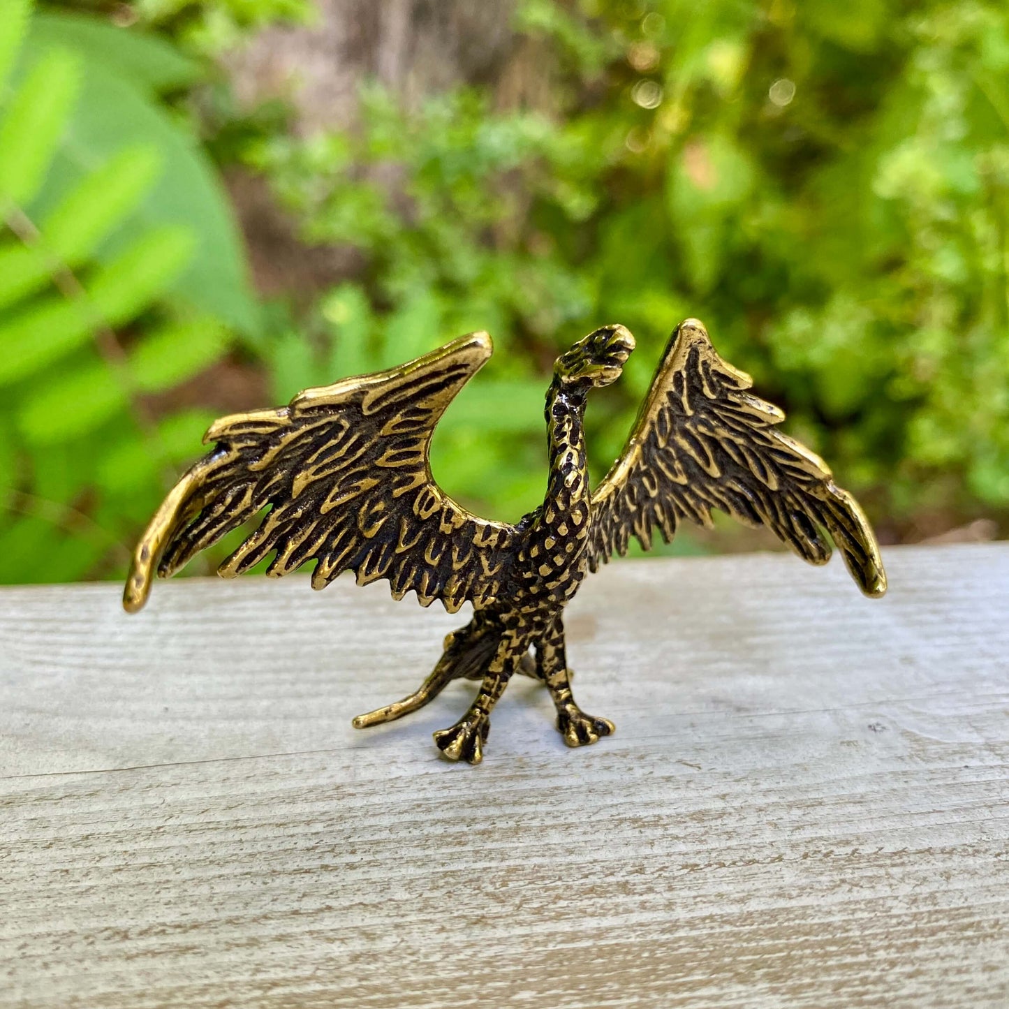 Solid brass phoenix sculpture by Wild Brass, featuring detailed wings and a regal stance symbolizing rebirth and strength.