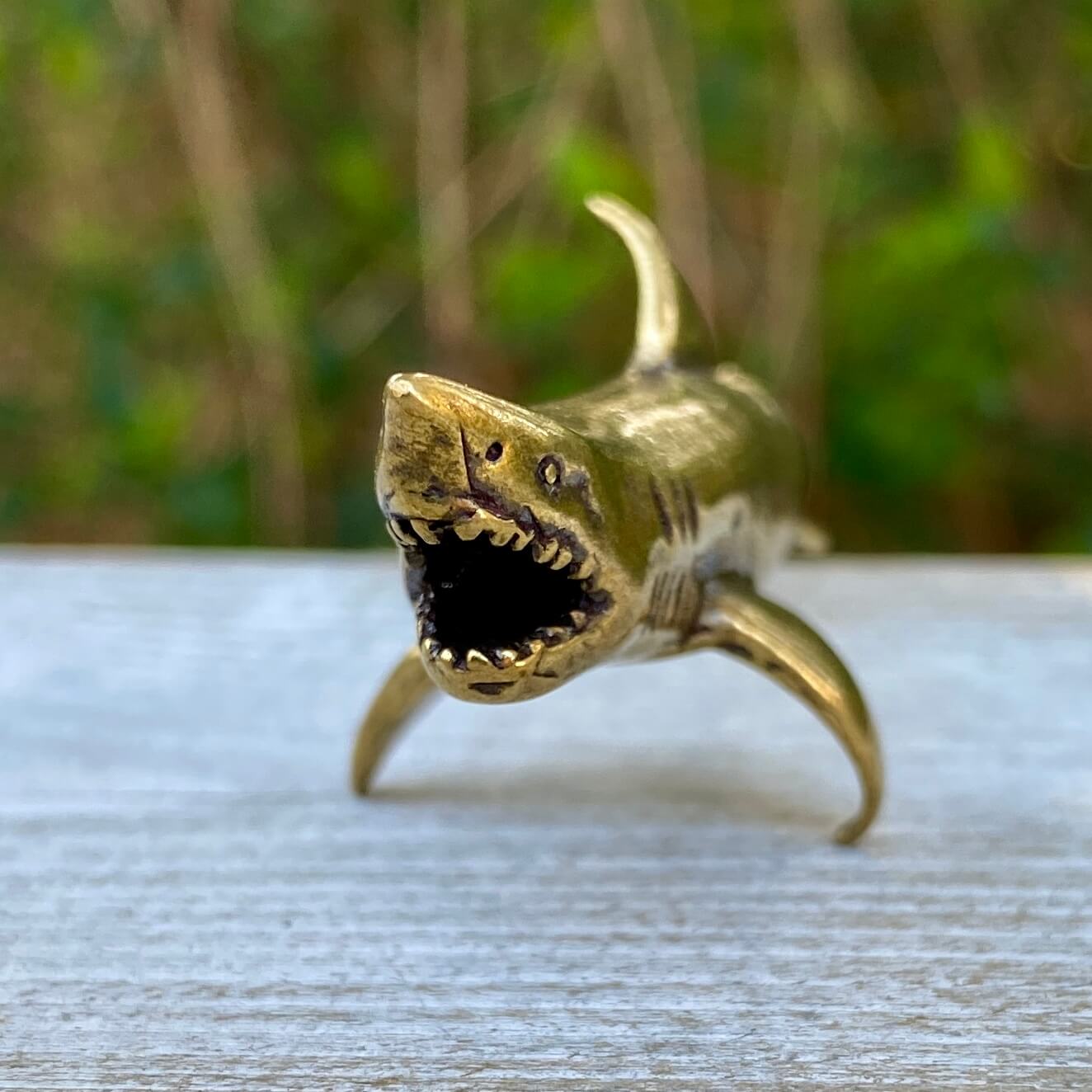 Solid brass shark sculpture by Wild Brass, symbolizing power, agility, and strength, displayed on a neutral background.