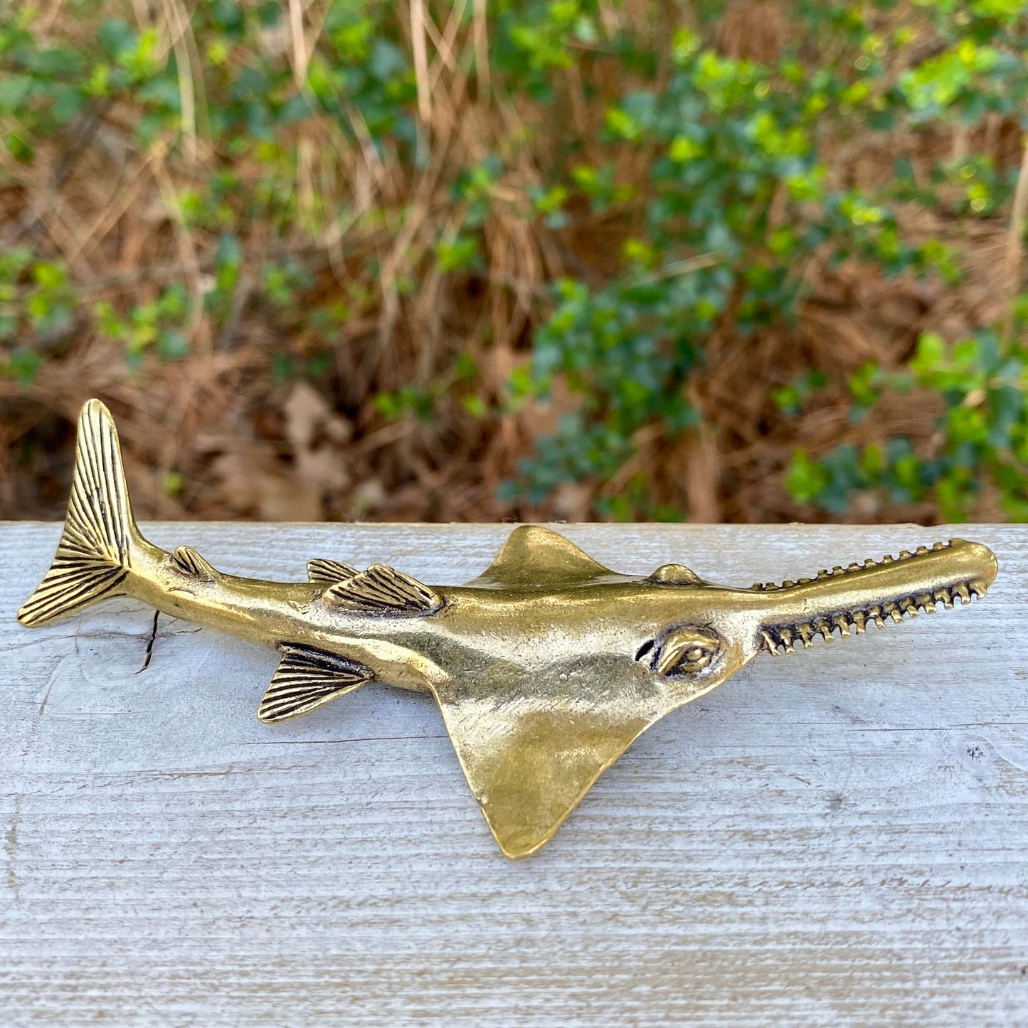 Solid brass sawfish sculpture by Wild Brass, featuring a detailed, sleek design symbolizing focus, power, and mystery.